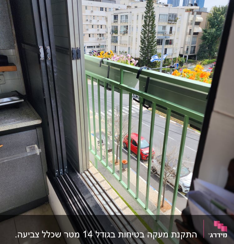 מסגרת חלון פתוחה עם נוף למרפסת וגדר ירוקה